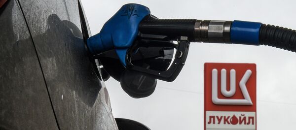 Заправочный пистолет в бензобаке автомобиля на автозаправочной станции Лукойл, архивное фото - Sputnik Тоҷикистон