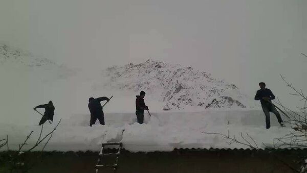 Молодые люди в Таджикистане убирают снег с крыш - Sputnik Таджикистан