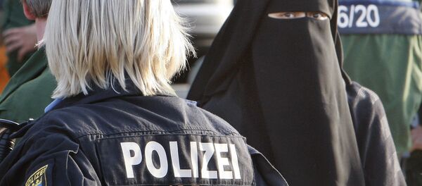 Сотрудница полиции Германии стоит напротив девушки в мусульманской одежде Сотрудница полиции Германии стоит напротив девушки в мусульманской одежде - Sputnik Таджикистан