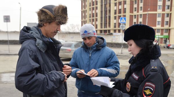 Лейтенант полиции проверяет документы у мигрантов - Sputnik Таджикистан
