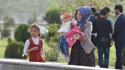 Женщина на улице с ребенком гуляют на улице Душанбе