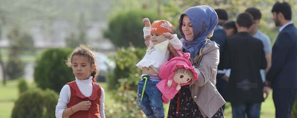 Женщина на улице с ребенком гуляют на улице Душанбе Женщина на улице с ребенком гуляют на улице Душанбе - Sputnik Тоҷикистон