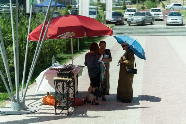 Люди под зонтом от солнца, архивное фото - Sputnik Таджикистан