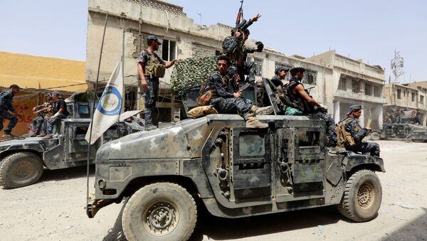 Полиция в Ираке на боевом автомобиле во время боев между военными и боевиками ИГИЛ в Мосуле, архивное фото - Sputnik Тоҷикистон
