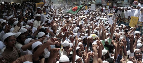 Сторонники Hefazat-e-Islam марша кричат лозунги после того, как полиция помешала им отправиться в посольство Мьянмы в знак протеста против преследования мусульман Рухинга Сторонники Hefazat-e-Islam марша кричат лозунги после того, как полиция помешала им отправиться в посольство Мьянмы в знак протеста против преследования мусульман Рухинга - Sputnik Таджикистан