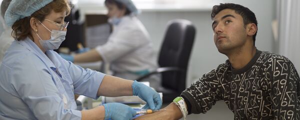 Cотрудник миграционного центра берет кровь мигранта для тестирования в московском миграционном центре в Сахарове, архивное фото - Sputnik Тоҷикистон