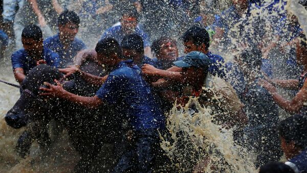 Люди брызгают водой на буйвола, подготавливая его к жертве во время Дашаина, крупнейшего религиозного праздника индуизма в Бхактапуре - Sputnik Таджикистан