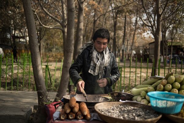 Юноша продает печеную кукурузу во дворе дома одного из районов Кабула - Sputnik Таджикистан