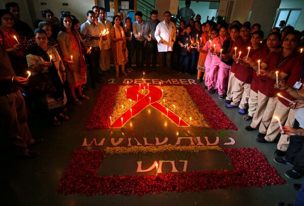Люди держат свечи во время церемонии посвященной всемирному дню борьбы со СПИДом в Ахмадабаде, Индия - Sputnik Таджикистан