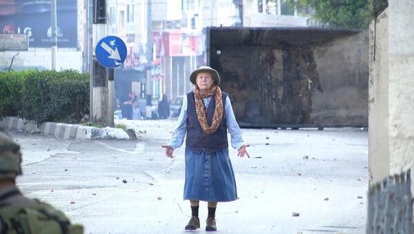Безоружная пожилая женщина встала между солдатами и протестующими в Вифлееме - Sputnik Таджикистан