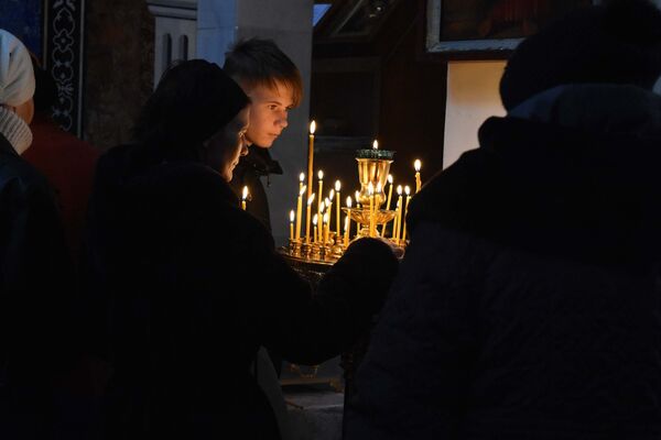 Православные прихожане ставят свечи, молясь - Sputnik Таджикистан