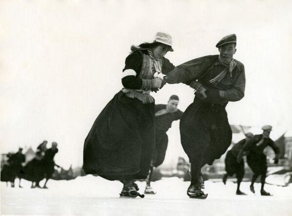 Катание на деревянных коньках в традиционных костюмах в Маркене, Нидерланды. 1938 год Архивное фото - Sputnik Таджикистан