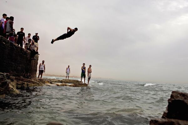 Местные жители спасаются от жары в море в Бенгази, Ливия - Sputnik Таджикистан