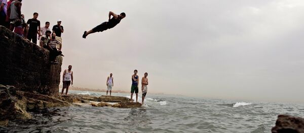 Местные жители спасаются от жары в море в Бенгази, Ливия - Sputnik Тоҷикистон