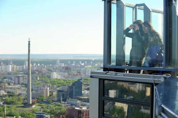 Жительницы Екатеринбурга рассматривают в бинокль панораму города со смотровой площадки небоскреба Высоцкий - Sputnik Таджикистан