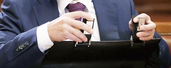 Мужчина закрывает портфель, архивное фото - Sputnik Тоҷикистон