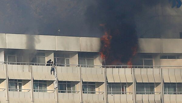 Мужчина пытается выбраться с балкона отеля Intercontinental в Кабуле во время нападения боевиков - Sputnik Тоҷикистон