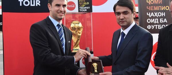Рустам Эмомали демонстрирует кубок чемпионата мира по футболу в Таджикистане - Sputnik Тоҷикистон