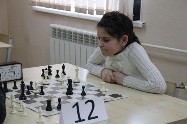 Юная участница сосредоточенно обдумывает ход - Sputnik Таджикистан