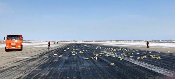 Взлетно-посадочная полоса аэропорта Якутск с рассыпанным грузом из самолёта Ан-12. 15 марта 2018 - Sputnik Тоҷикистон