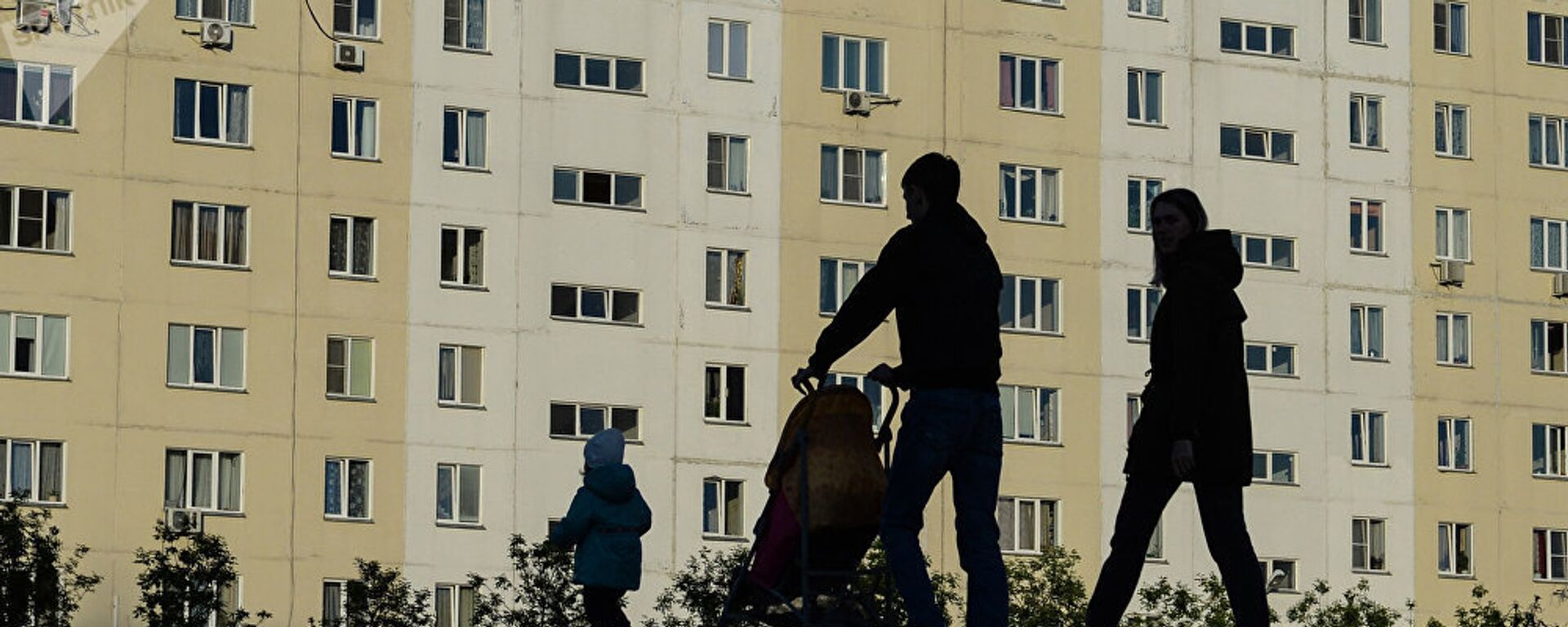 Мужчина и женщина с ребенком идут по тротуару. Архивное фото - Sputnik Тоҷикистон, 1920, 29.11.2021