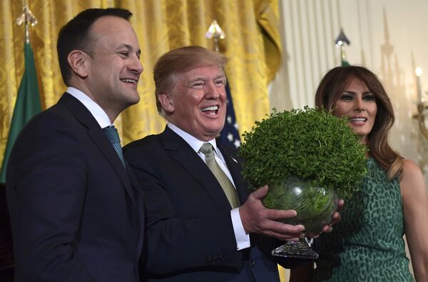 Президент США Дональд Трамп, в центре, улыбается, когда ему вручают чашу из клещей от ирландского премьер-министра Лео Варадкара - Sputnik Таджикистан