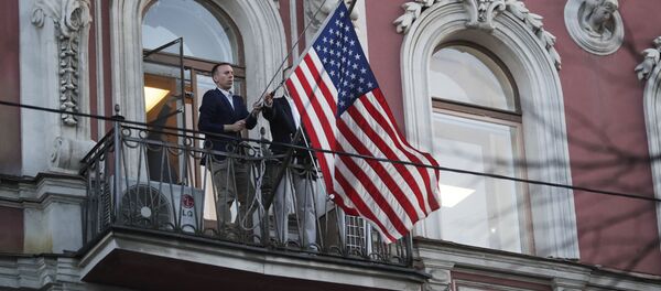 Сотрудники дипмиссии снимают государственный флаг США со здания американского генконсульства на Фурштатской улице в Санкт-Петербурге - Sputnik Таджикистан