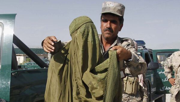Афганский полицейский арестовывает боевика переодетого в женскую одежду. Архивное фото - Sputnik Таджикистан