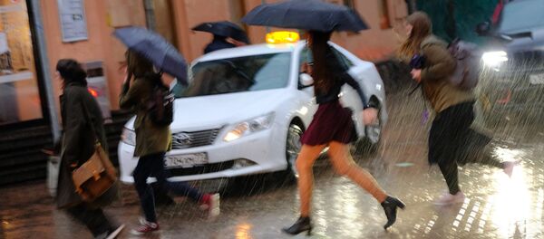 Пешеходы на улице в Москве во время сильного дождя. - Sputnik Тоҷикистон