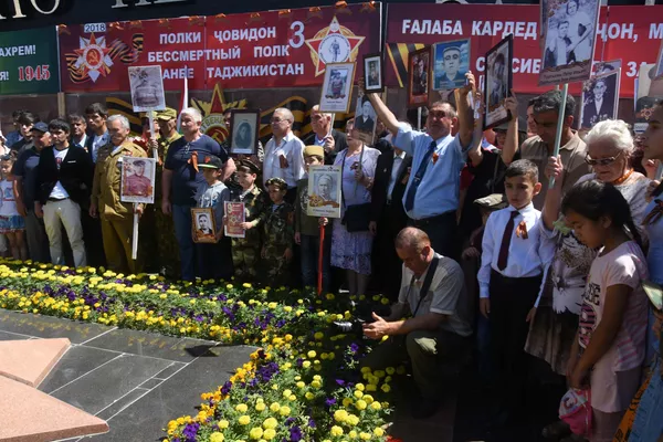 Дар Боғи Ғалаба иширокдорони Ҳанги ҷовидон дар назди Оташи ҷовидон ва ҳайкали ҷанговарони кушташуда гул гузошатнд Дар Боғи Ғалаба иширокдорони Ҳанги ҷовидон дар назди Оташи ҷовидон ва ҳайкали ҷанговарони кушташуда гул гузошатнд - Sputnik Тоҷикистон
