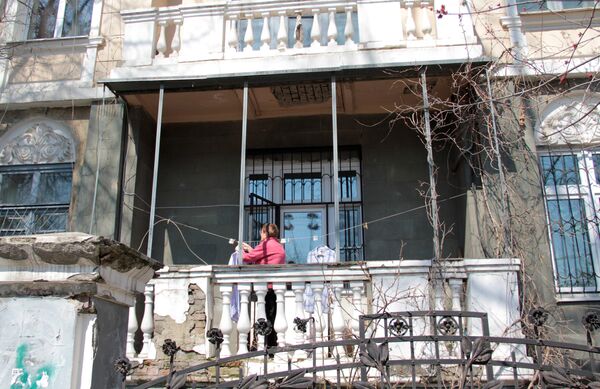Центр города. Женщина развешивает белье на балконе старинной усадьбы. - Sputnik Таджикистан