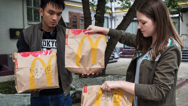 Молодые люди держат пакеты с едой из McDonald’s - Sputnik Таджикистан