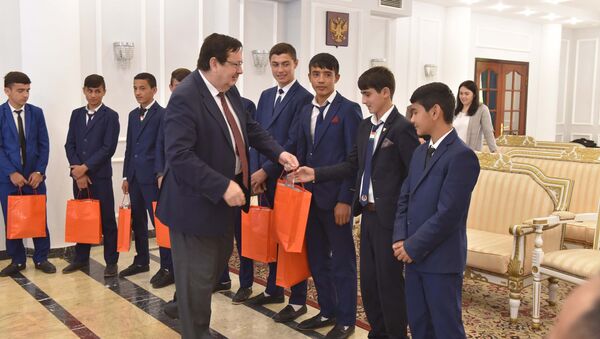Посол России Игорь Лякин-Фролов раздаёт подарки юным футболистам, архивное фото - Sputnik Таджикистан