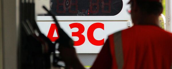 Заправщик возвращает заправочный пистолет в слот - Sputnik Таджикистан