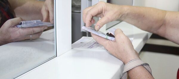 Женщина считает банкноты после обмена валюты в филиале Национального банка Узбекистана в Ташкенте - Sputnik Тоҷикистон