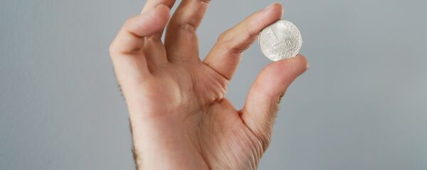 Монета один сомони в руке, архивное фото - Sputnik Таджикистан