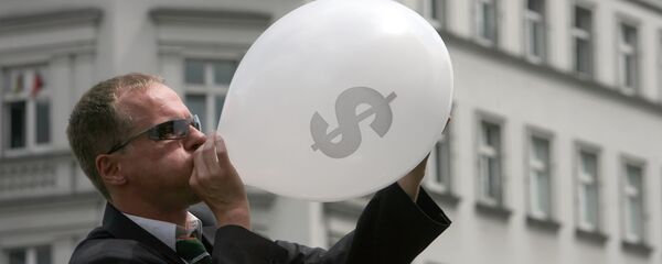 Человек в костюме надувает воздушный шар со значком американского доллара, архивное фото - Sputnik Таджикистан