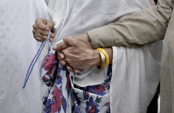 Пожилая мусульманка держит за руку своего мужа во время хаджа, архивное фото - Sputnik Таджикистан