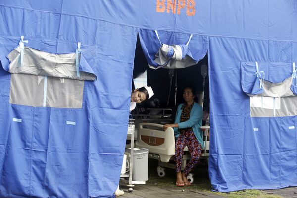 Медсестра выглядывает из шатра полевого госпиталя на острове Бали - Sputnik Таджикистан