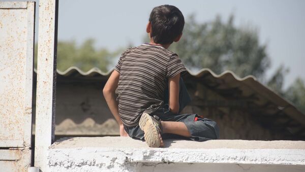 Мальчик сидит на заборе, архивное фото - Sputnik Таджикистан