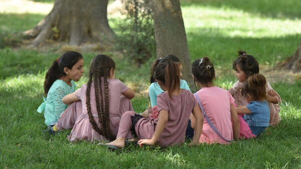 Дети сидят на траве в парке, архивное фото - Sputnik Тоҷикистон