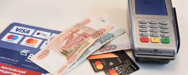 Терминал оплаты банковскими картами и денежные купюры, архивное фото Терминал оплаты банковскими картами и денежные купюры, архивное фото - Sputnik Таджикистан