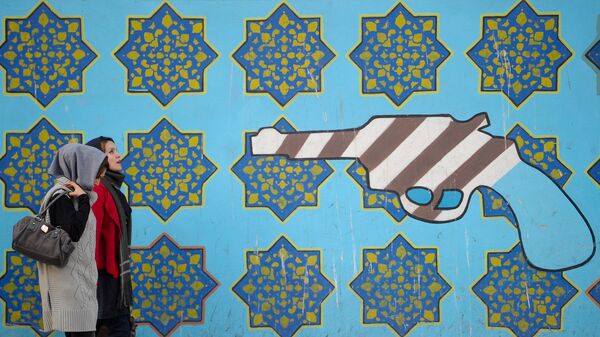 Женщины идут вдоль стены здания бывшего посольства США в Тегеране - Sputnik Таджикистан