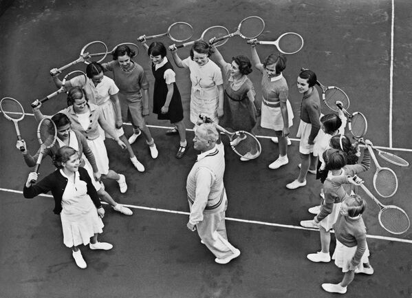 Школьницы слушают учителя тенниса в теннисном клубе Welsby Court в Лондоне, архивное фото - Sputnik Таджикистан