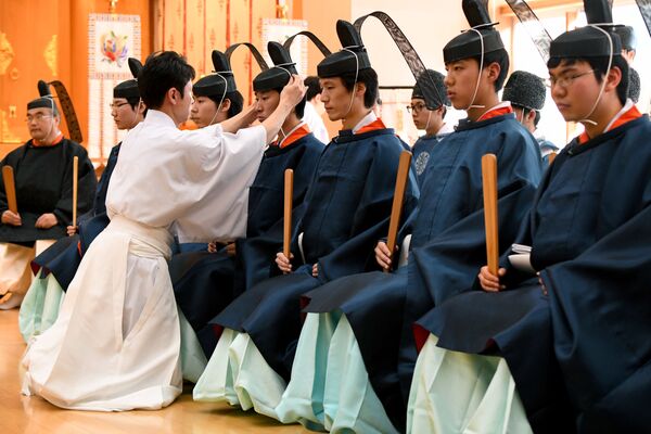 Учитель одевает корону на голове студента, во время традиционной церемонии взрослой жизни в Университете Кокугакуин в Токио, архивное фото - Sputnik Таджикистан