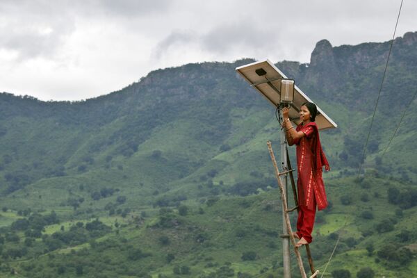 Девушка подключает солнечную панель в горах Индии, архивное фото - Sputnik Таджикистан