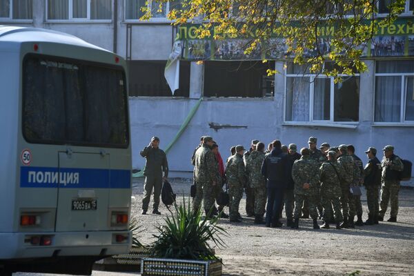 Сотрудники правоохранительных органов у здания Керченского политехнического колледжа, в котором произошли взрыв и стрельба - Sputnik Таджикистан