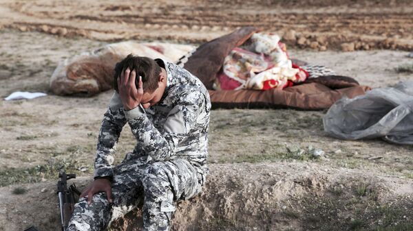 Иракский полицейский на месте массового захоронения, архивное фото - Sputnik Тоҷикистон