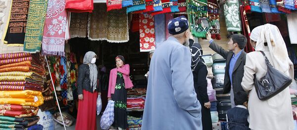 Уйгурские мусульмане выбирают молельные коврики на рынке в Хотане - Sputnik Таджикистан