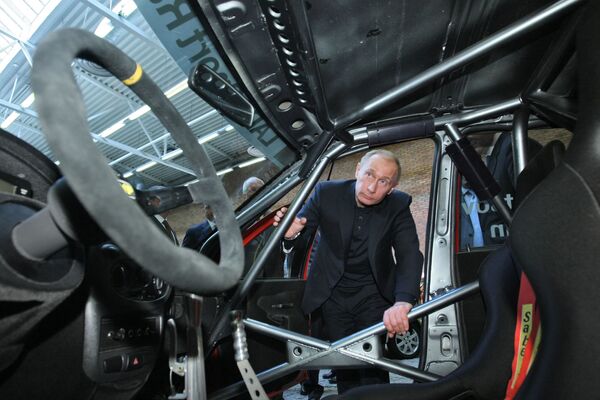 Председатель правительства РФ Владимир Путин осматривает модельный ряд автомобилей АВТОВАЗа - Sputnik Таджикистан